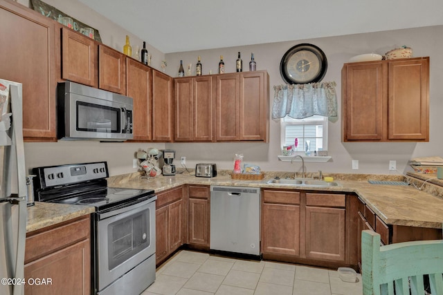 kitchen with sink, stainless steel appliances, and light tile patterned flooring