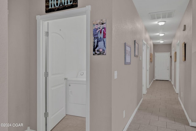 hall featuring light tile patterned floors and washer / clothes dryer