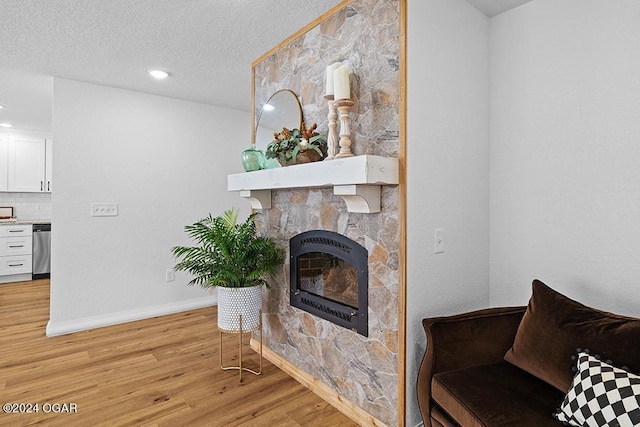 living room featuring light wood-type flooring and a textured ceiling