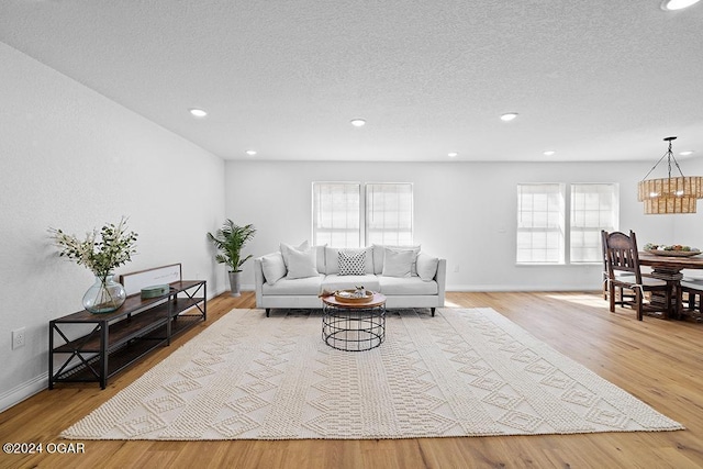 living room featuring plenty of natural light, light hardwood / wood-style floors, and a textured ceiling