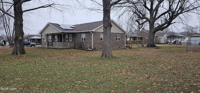 view of home's exterior with a yard, covered porch, and solar panels