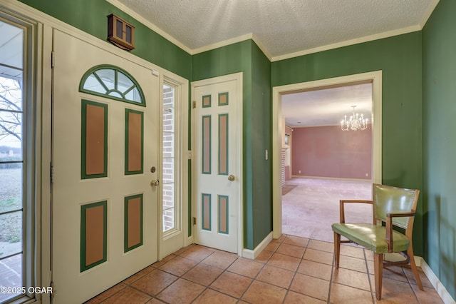 tiled foyer entrance with ornamental molding, a textured ceiling, and an inviting chandelier