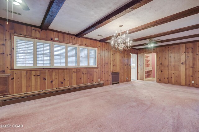 unfurnished living room with baseboard heating, a wealth of natural light, carpet flooring, and beam ceiling