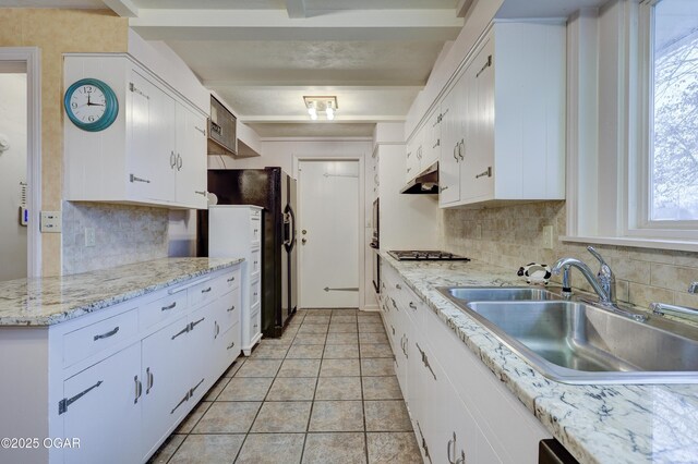 kitchen featuring stainless steel gas stovetop, white cabinets, sink, beamed ceiling, and light tile patterned flooring