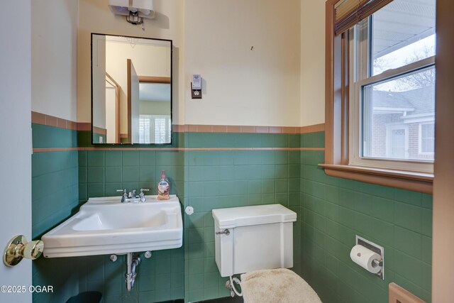 bathroom featuring a wealth of natural light, tile walls, and sink