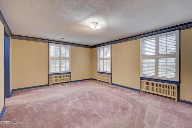 carpeted spare room with radiator heating unit, a textured ceiling, and ornamental molding