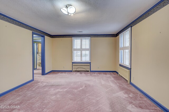 unfurnished room with radiator, carpet floors, a textured ceiling, and ornamental molding