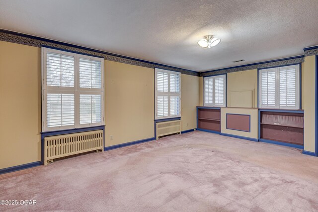 spare room featuring radiator and a healthy amount of sunlight