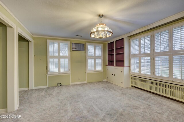 unfurnished bedroom featuring a chandelier, radiator heating unit, light colored carpet, and ornamental molding