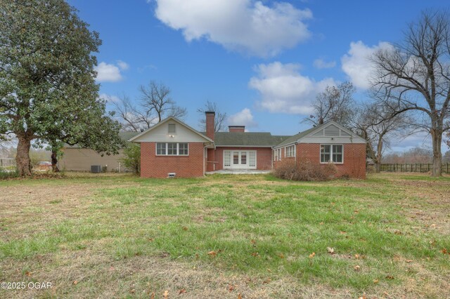 rear view of property with a yard