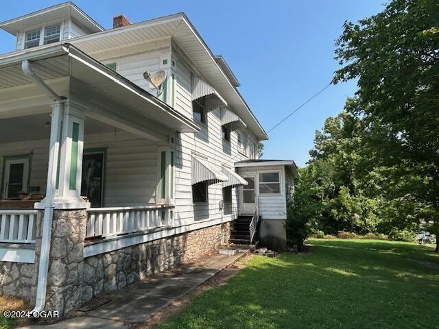 view of home's exterior featuring a yard and covered porch