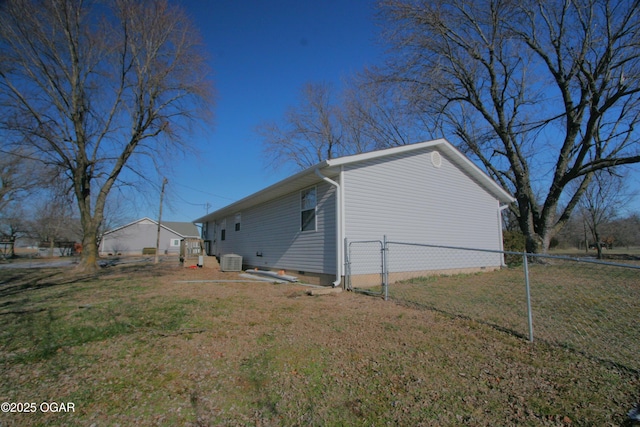 view of home's exterior with central air condition unit and a yard