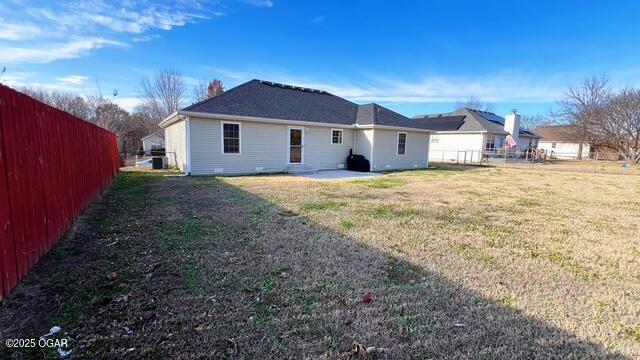 back of house featuring a lawn and a patio area