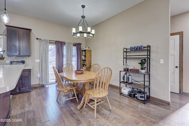 dining area with light hardwood / wood-style flooring and an inviting chandelier