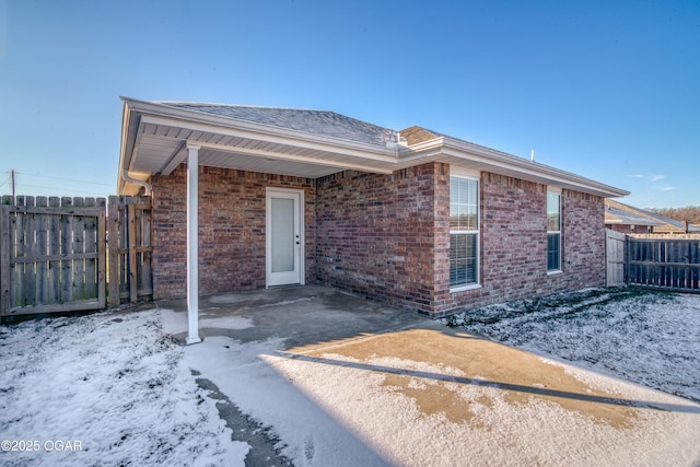 snow covered property featuring a patio