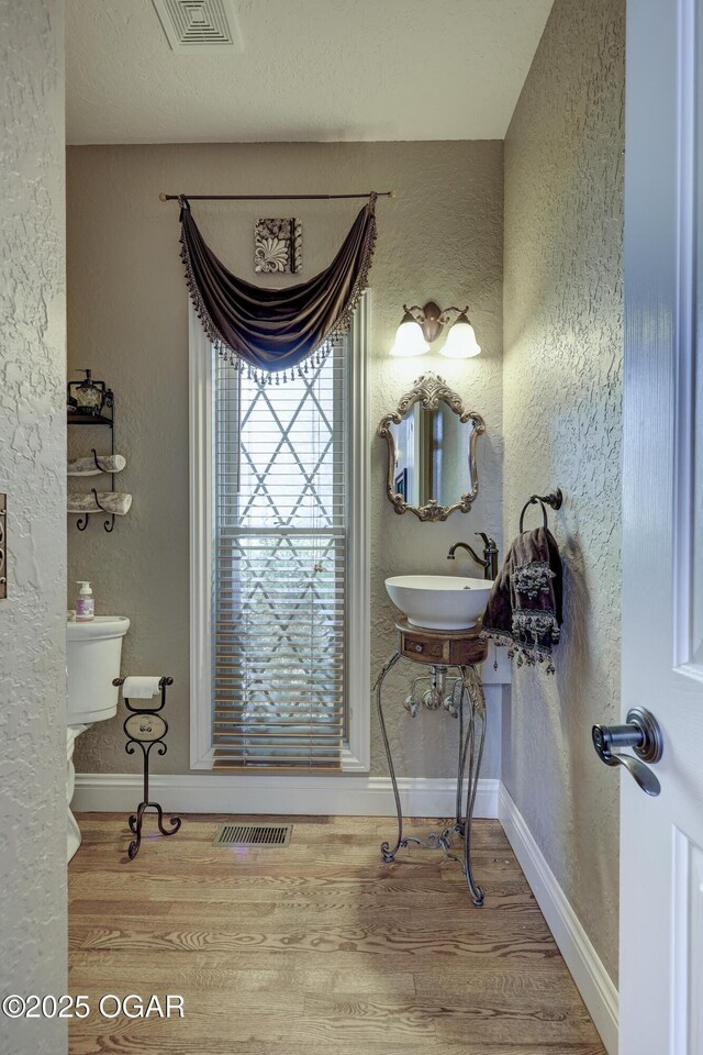 bathroom with hardwood / wood-style flooring, toilet, and sink