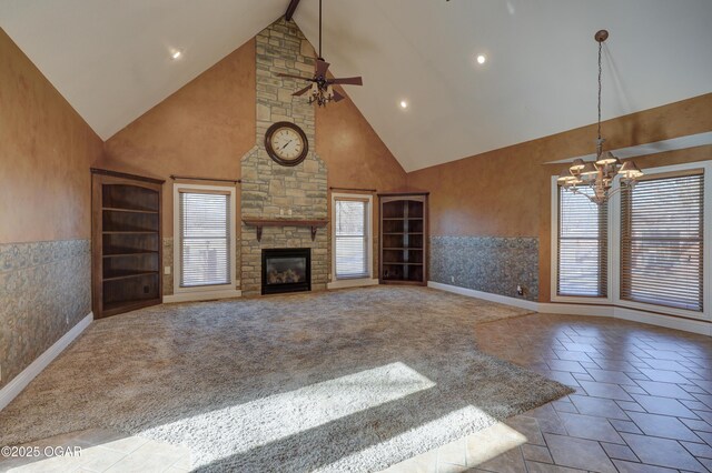 unfurnished living room featuring light carpet, high vaulted ceiling, ceiling fan with notable chandelier, a fireplace, and beam ceiling