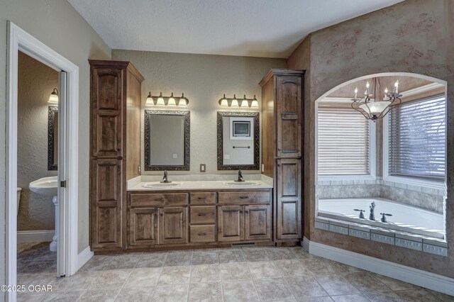 bathroom featuring tile patterned flooring, a relaxing tiled tub, a chandelier, a textured ceiling, and vanity