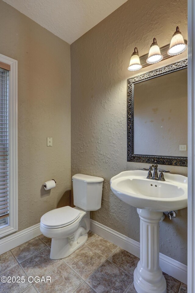 bathroom featuring a textured ceiling and toilet