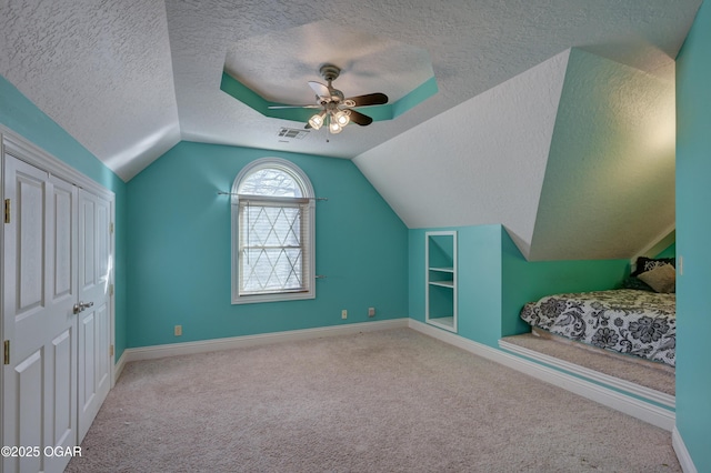 additional living space featuring vaulted ceiling, carpet flooring, built in shelves, ceiling fan, and a textured ceiling