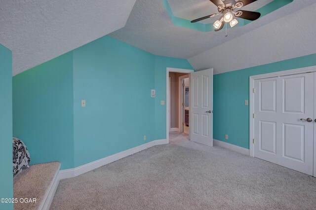 bonus room with a textured ceiling, ceiling fan, light carpet, and lofted ceiling