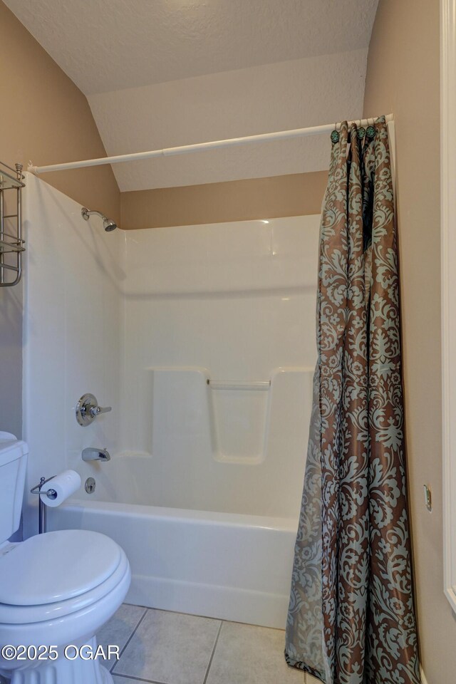 bathroom with tile patterned flooring, shower / bath combo, toilet, and a textured ceiling