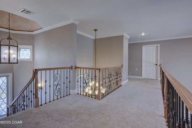 hall with light carpet, crown molding, and a notable chandelier