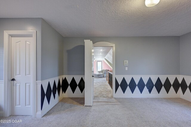 carpeted spare room featuring a textured ceiling