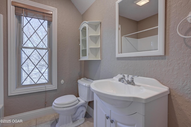 bathroom with tile patterned flooring, vanity, lofted ceiling, and toilet