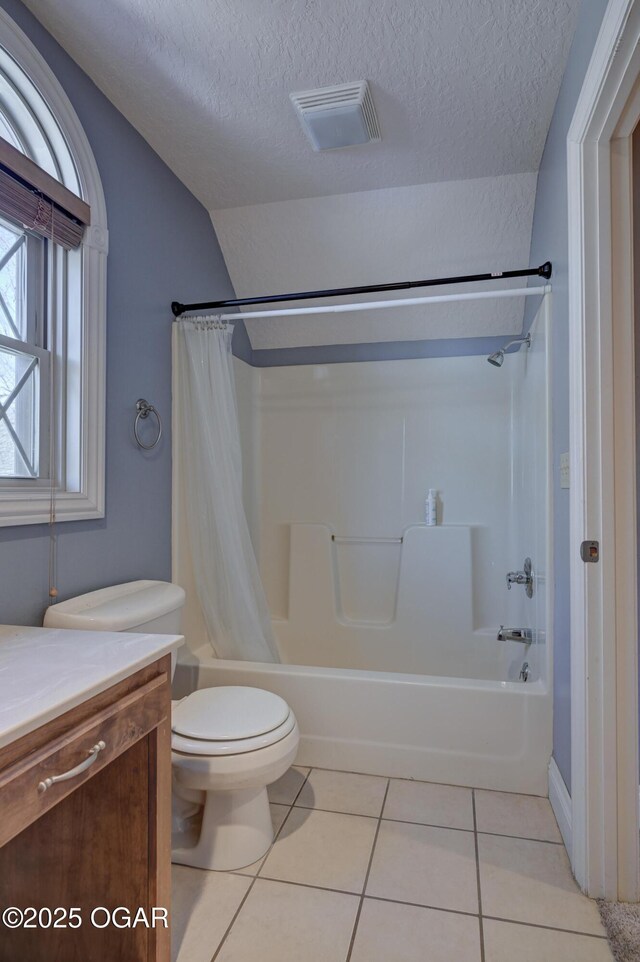 full bathroom with tile patterned flooring, a textured ceiling, toilet, shower / bath combo with shower curtain, and vanity