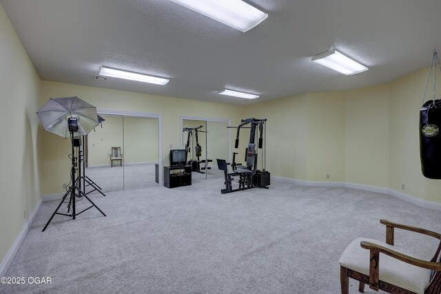 exercise area featuring a textured ceiling and light carpet