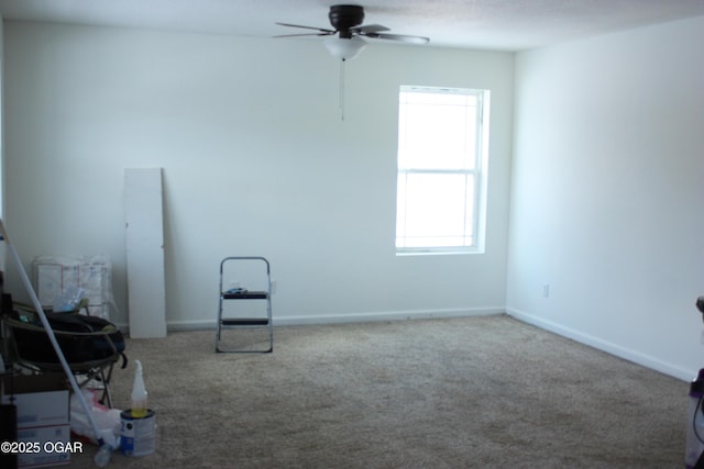 empty room with carpet floors, plenty of natural light, and ceiling fan