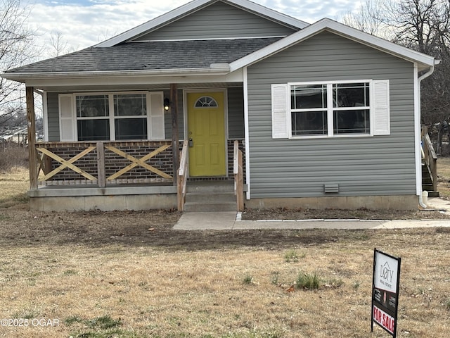 view of front of house with covered porch and a front lawn