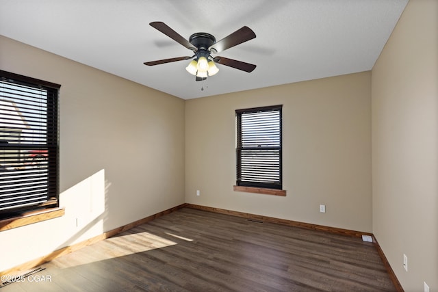 spare room with ceiling fan and dark hardwood / wood-style flooring