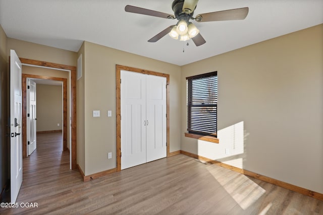 unfurnished bedroom with light hardwood / wood-style floors, a closet, and ceiling fan