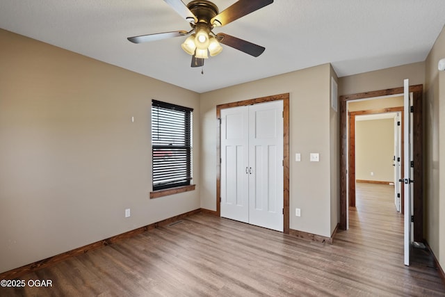 unfurnished bedroom with a closet, light hardwood / wood-style flooring, and ceiling fan