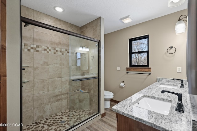 bathroom with hardwood / wood-style flooring, vanity, toilet, and walk in shower