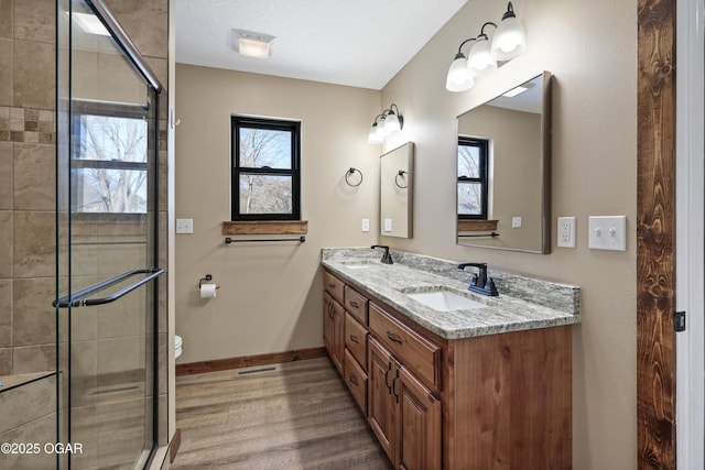 bathroom with vanity, toilet, wood-type flooring, and walk in shower