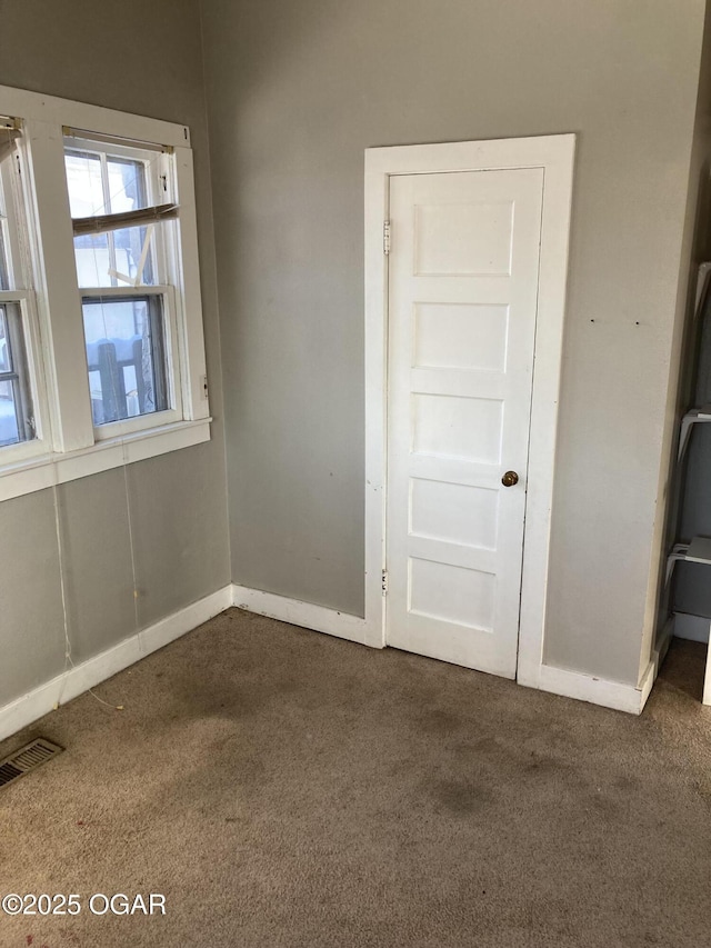 unfurnished bedroom with dark colored carpet