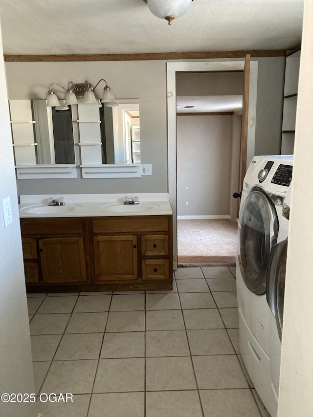 laundry area featuring light tile patterned floors, a textured ceiling, and sink