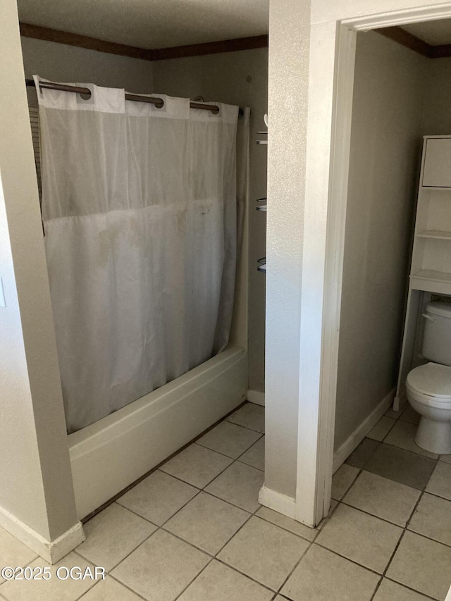 bathroom featuring tile patterned flooring, shower / bath combo, and toilet