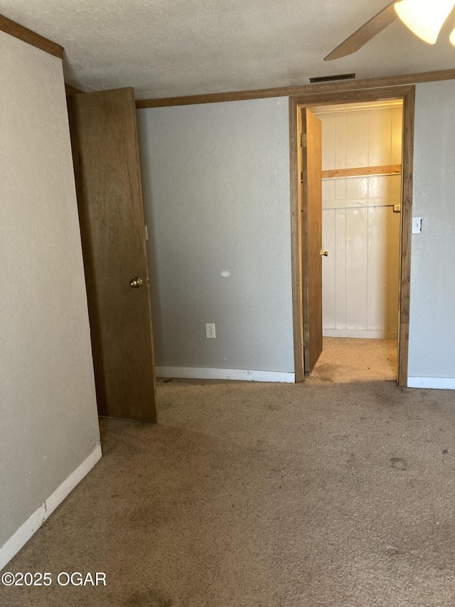 unfurnished room featuring carpet flooring, ceiling fan, and a textured ceiling