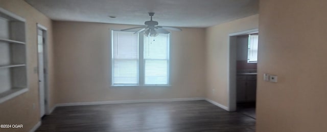 empty room with ceiling fan and dark hardwood / wood-style floors