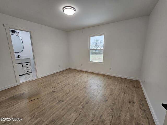 unfurnished room featuring sink and light wood-type flooring