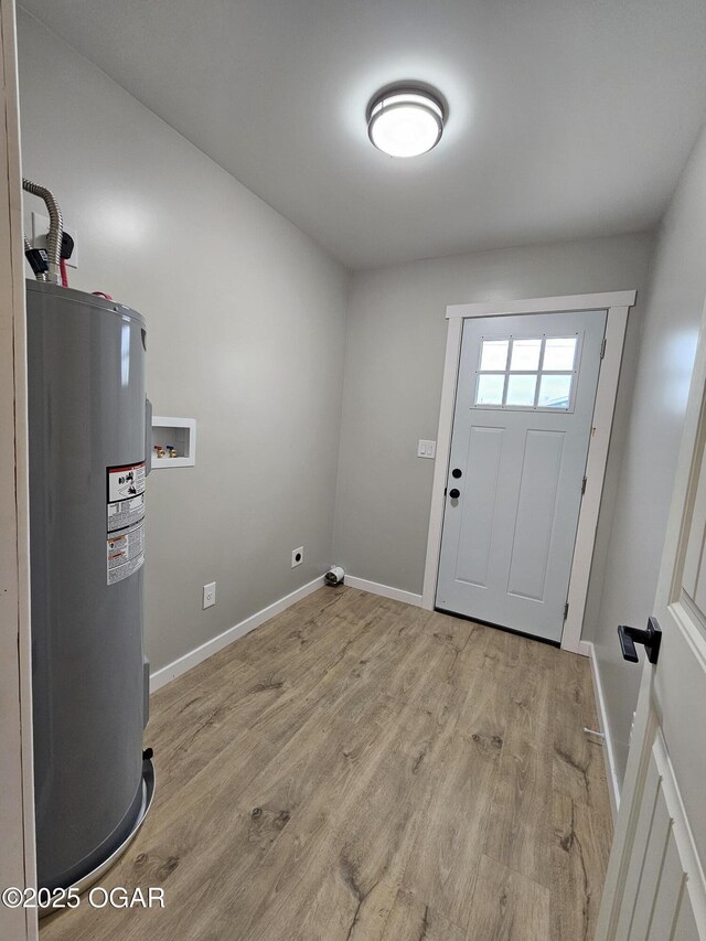 laundry area with washer hookup, water heater, and light hardwood / wood-style flooring