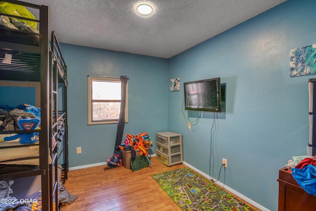 bedroom with a textured ceiling and hardwood / wood-style flooring