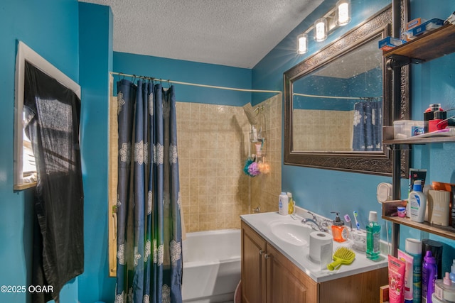 bathroom with a textured ceiling, vanity, and shower / bath combo with shower curtain