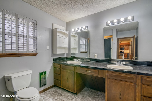 bathroom with vanity, a textured ceiling, and toilet