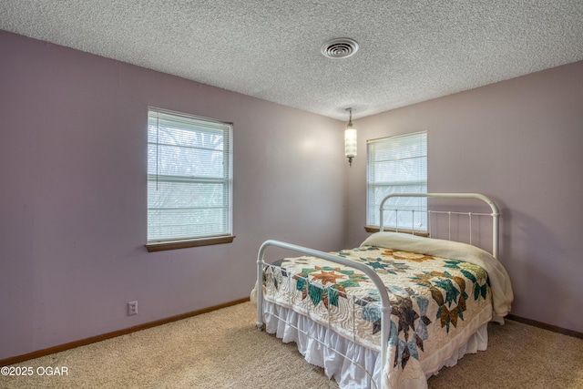 bedroom with carpet floors and a textured ceiling