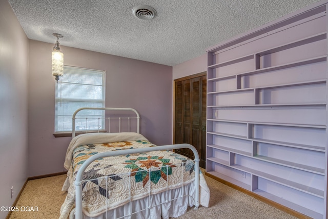 carpeted bedroom featuring a textured ceiling and a closet